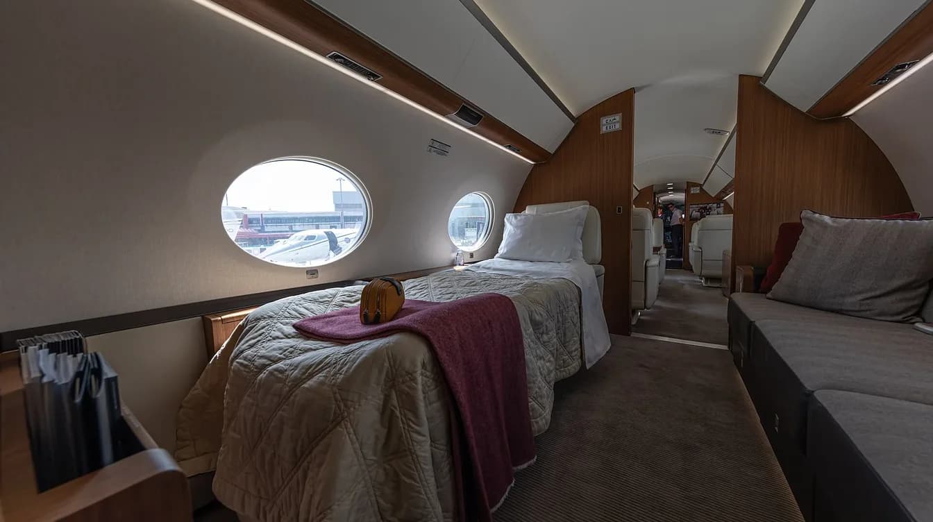 Gulfstream stateroom with a made bed beside oval cabin windows